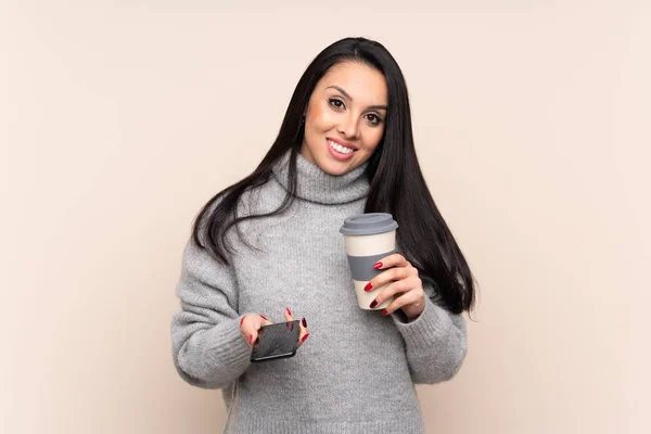 Jovem Colombiana Sobre Fundo Isolado Segurando Café Para Levar Celular — Fotografia de Stock