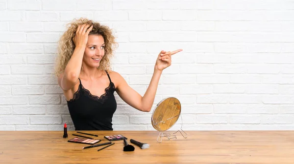 Mujer Joven Con Mucho Cepillo Maquillaje Una Mesa Sorprendida Señalando — Foto de Stock