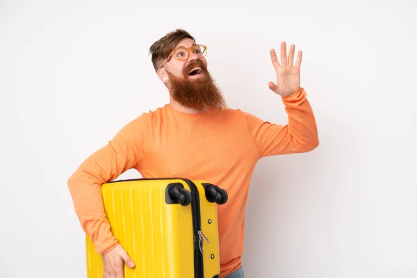 旅行时 红头发男人留着长胡子 白色背景 背着旅行箱 举手投足致意 — 图库照片