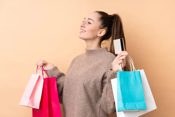 Joven Morena Sobre Fondo Aislado Sosteniendo Bolsas Compras Una Tarjeta — Foto de Stock