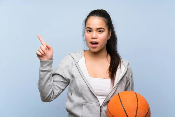 Jong Aziatisch Meisje Spelen Basketbal Geïsoleerde Achtergrond Verrast Wijzend Vinger — Stockfoto