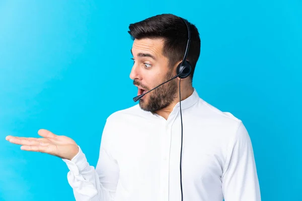 Hombre Telemarketer Trabajando Con Auricular Sobre Fondo Azul Aislado Sosteniendo — Foto de Stock