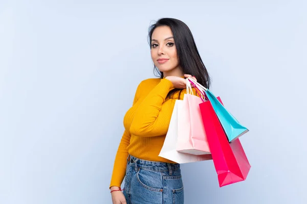 Joven Colombiana Sobre Fondo Azul Aislado Sosteniendo Bolsas Compras —  Fotos de Stock