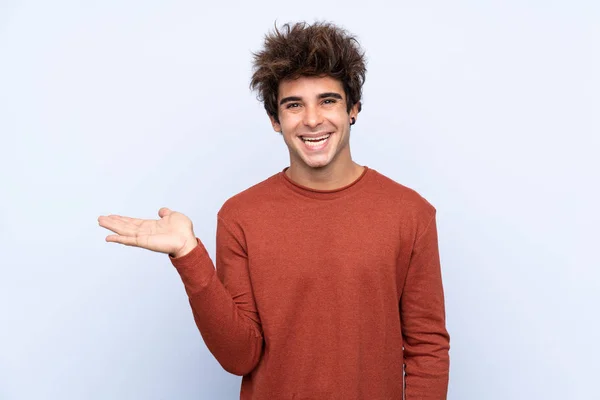 Joven Hombre Caucásico Sobre Fondo Azul Aislado Sosteniendo Espacio Copia —  Fotos de Stock