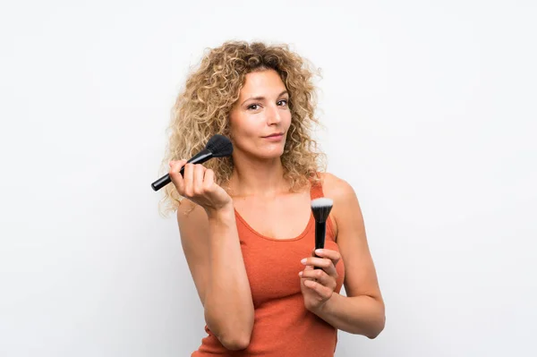 Ung blond kvinna med lockigt hår med makeup borste — Stockfoto