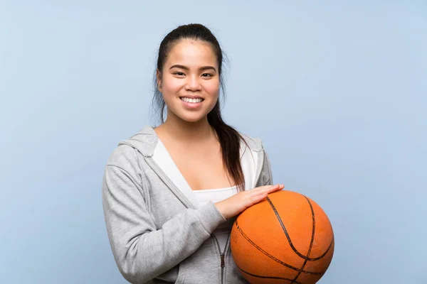 Jonge Aziatische meisje spelen basketbal over geïsoleerde achtergrond — Stockfoto