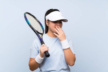 Genç Asyalı kız çok fazla gülümseyerek tenis oynuyor.