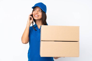 Genç teslimatçı esmer kız izole edilmiş beyaz arka planda elinde kahve ve cep telefonu var.