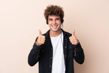 Tele pazarlamacı, izole edilmiş arka plan üzerinde çalışan bir kulaklıkla baş parmak işareti yapıyor.