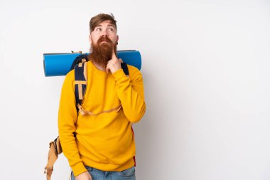İzole edilmiş beyaz bir arka plan üzerine büyük bir sırt çantası olan genç dağcı bir fikir düşünüyor.