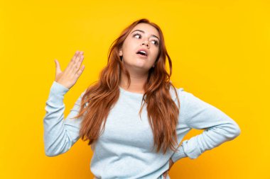 Yorgun ve hasta ifade ile izole sarı arka plan üzerinde Genç redhead kız