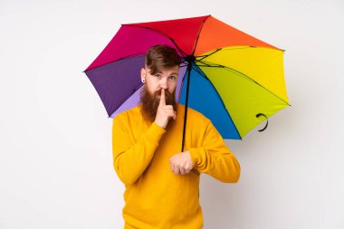 Kızıl saçlı, uzun sakallı, şemsiyeli, izole edilmiş beyaz arka planda sessiz hareketler yapan bir adam.