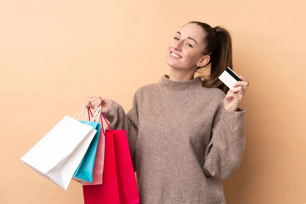 Jonge Brunette Vrouw Geïsoleerde Achtergrond Holding Boodschappentassen Een Creditcard — Stockfoto