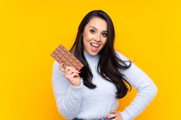 Mladá Kolumbijská Dívka Přes Izolované Žluté Pozadí Čokoládovou Tabletu Šťastný — Stock fotografie
