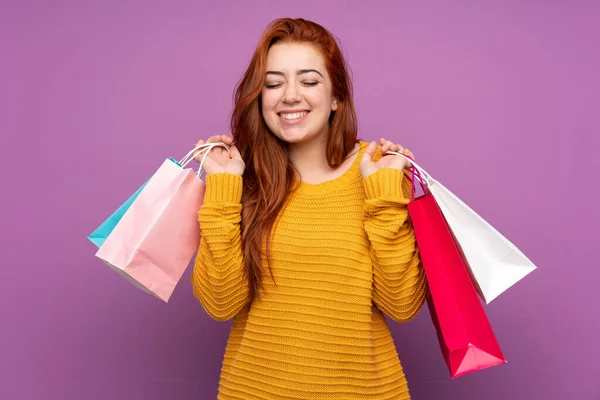 소녀가 쇼핑백을 웃으며 외로운 보라색 배경을 — 스톡 사진