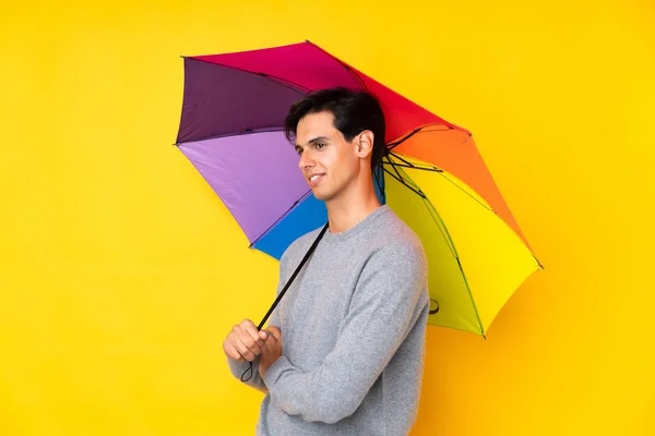 Muž Drží Deštník Nad Izolovaným Žlutým Pozadím Dívá Strany — Stock fotografie