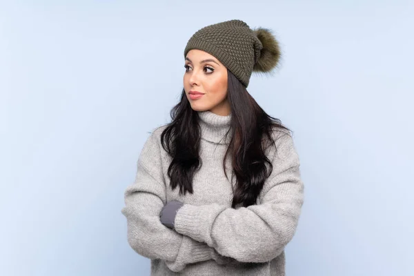 Young Colombian Girl Winter Hat Isolated Blue Background Looking Side — 스톡 사진
