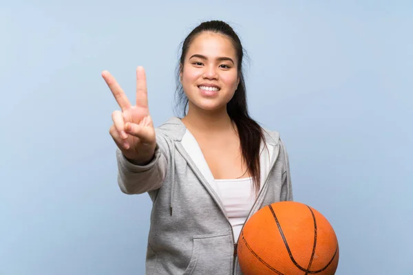 Young Asian Girl Playing Basketball Isolated Background Smiling Showing Victory — 스톡 사진