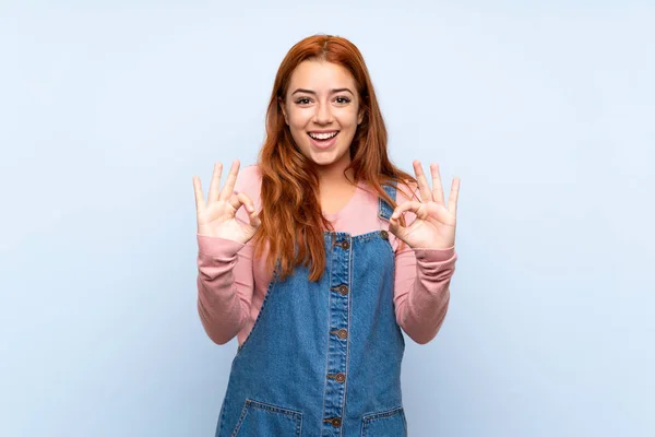 Teenager Redhead Girl Overalls Isolated Blue Background Showing Sign Fingers — 스톡 사진