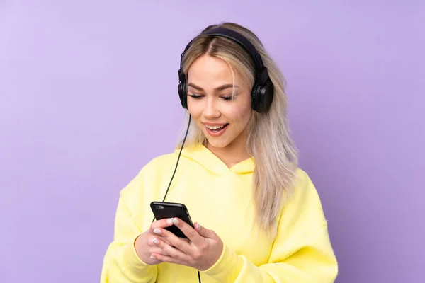 Teenager Girl Isolated Purple Background Listening Music Looking Mobile — 스톡 사진