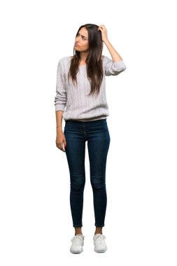 A full-length shot of a Young hispanic brunette woman having doubts while scratching head over isolated white background