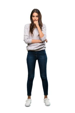 A full-length shot of a Young hispanic brunette woman thinking over isolated white background