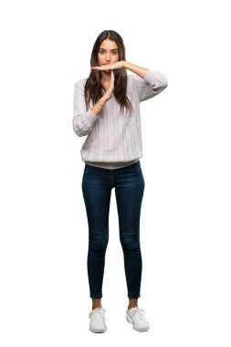 A full-length shot of a Young hispanic brunette woman making time out gesture over isolated white background