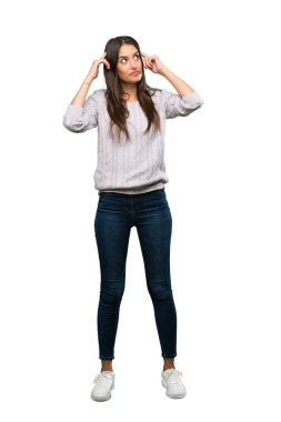 A full-length shot of a Young hispanic brunette woman having doubts and thinking over isolated white background