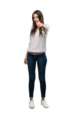 A full-length shot of a Young hispanic brunette woman with thumbs up because something good has happened over isolated white background