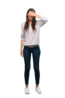 A full-length shot of a Young hispanic brunette woman covering eyes by hands. Do not want to see something over isolated white background