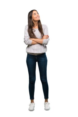 A full-length shot of a Young hispanic brunette woman looking up while smiling over isolated white background