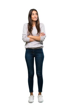 A full-length shot of a Young hispanic brunette woman with confuse face expression over isolated white background