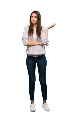 A full-length shot of a Young hispanic brunette woman unhappy for not understand something over isolated white background