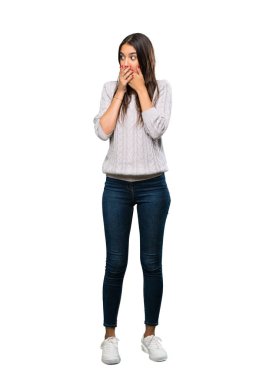 A full-length shot of a Young hispanic brunette woman covering mouth and looking to the side over isolated white background