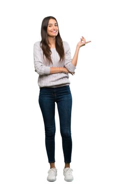 A full-length shot of a Young hispanic brunette woman pointing finger to the side over isolated white background