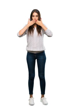 A full-length shot of a Young hispanic brunette woman covering mouth with hands over isolated white background