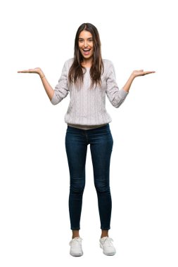 A full-length shot of a Young hispanic brunette woman with shocked facial expression over isolated white background