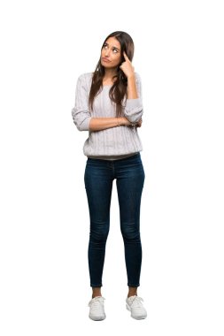 A full-length shot of a Young hispanic brunette woman making the gesture of madness putting finger on the head over isolated white background