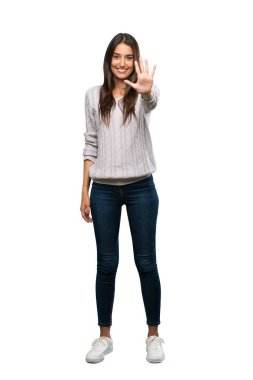 A full-length shot of a Young hispanic brunette woman counting five with fingers over isolated white background
