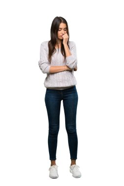 A full-length shot of a Young hispanic brunette woman having doubts over isolated white background