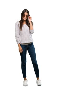 A full-length shot of a Young hispanic brunette woman with glasses and smiling over isolated white background