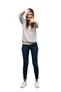 A full-length shot of a Young hispanic brunette woman focusing face. Framing symbol over isolated white background