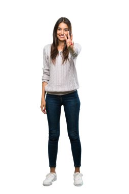 A full-length shot of a Young hispanic brunette woman happy and counting three with fingers over isolated white background