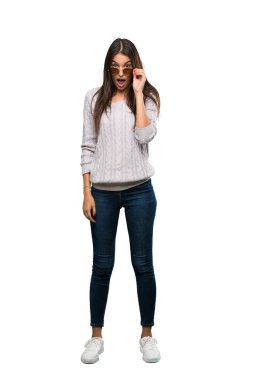 A full-length shot of a Young hispanic brunette woman with glasses and surprised over isolated white background
