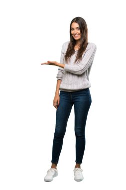 A full-length shot of a Young hispanic brunette woman presenting an idea while looking smiling towards over isolated white background