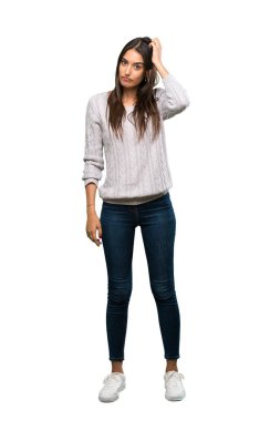 A full-length shot of a Young hispanic brunette woman with an expression of frustration and not understanding over isolated white background
