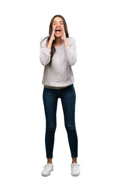 A full-length shot of a Young hispanic brunette woman shouting and announcing something over isolated white background