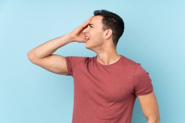 Mavi arka planda izole genç beyaz yakışıklı adam bir şey fark etti ve çözüme niyetlendi.