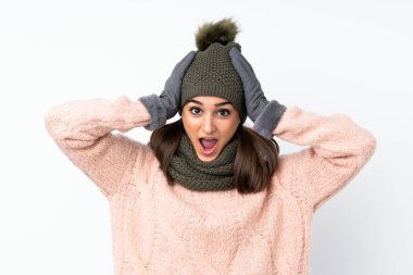 Kışlık şapkalı genç bir kız izole edilmiş beyaz bir geçmişi var ve yüzünde sürpriz bir ifade var.