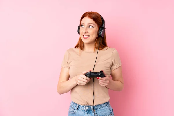 Jonge Roodharige Vrouw Geïsoleerde Roze Achtergrond Spelen Videogames — Stockfoto